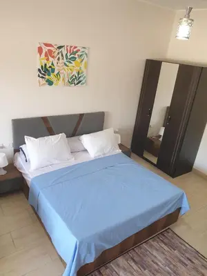 a bedroom with a blue bed and a mirror at 3316- Awesome Garden view studio in Al Dau Heights in Hurghada