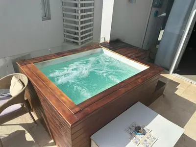 a large wooden tub with a pool of water at 1BR with private Heated Jacuzzi at Sholan Elgouna in Hurghada