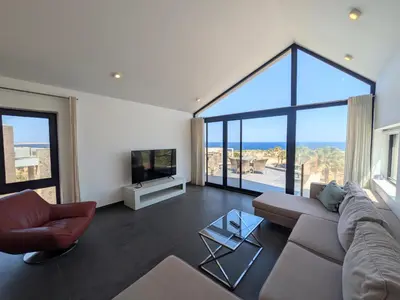 a living room with a couch and a tv at Sea & Golf Views 2BR Villa with Free Beach & Pool Access in Hurghada