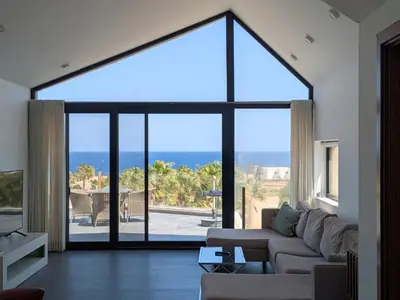 a living room with a couch and a large window at Sea & Golf Views 2BR Villa with Free Beach & Pool Access in Hurghada