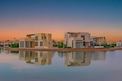 a row of houses with their reflections in the water at Comfy 3BR Standalone in Tawila, El Gouna. Lagoon & Pool access in Hurghada