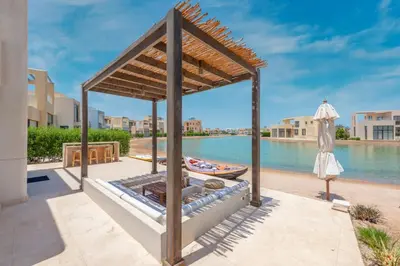a gazebo with a boat in the water at Comfy 3BR Standalone in Tawila, El Gouna. Lagoon & Pool access in Hurghada