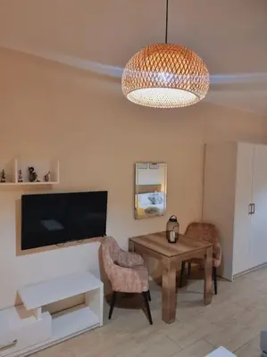 a living room with a table and chairs and a television at Tolles Modernes Studio in Aldau in Hurghada