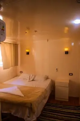 a bedroom with two beds and a window at Floating Hotel- Happy Nile Boat in Luxor