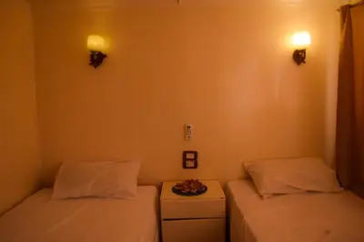 a room with two beds and a table with a plate on it at Floating Hotel- Happy Nile Boat in Luxor