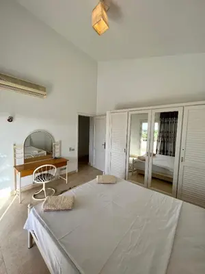 a bedroom with a large white bed and a desk at GS 23 in Hurghada