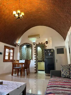 a living room with a table and a kitchen at The House Of Love in Luxor