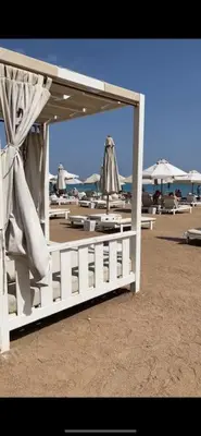 a white fence on the beach with umbrellas at Stunning Pool View 1bed Private Beach Access, Veranda Sahl Hasheesh in Hurghada