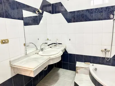 a bathroom with two sinks and a tub at Sunset Haven Guesthouse in Luxor