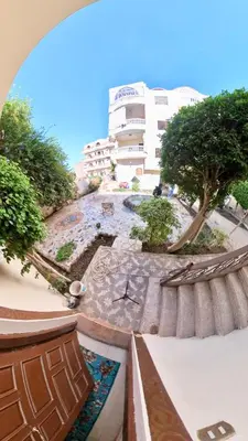 a view of a courtyard with a building in the background at Sunset Haven Guesthouse in Luxor