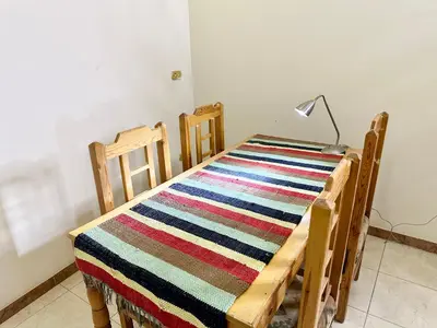a room with a table with a striped rug and a lamp at Sunset Haven Guesthouse in Luxor
