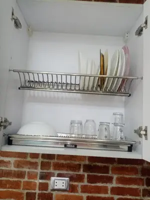 a shelf in a kitchen with plates and dishes at Makramia studio in Hurghada
