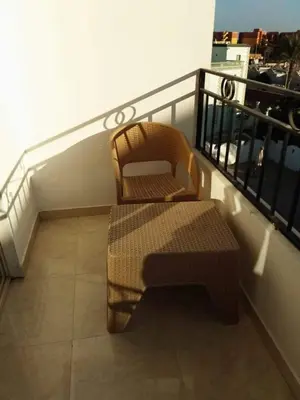 a chair and a bench on a balcony at Makramia studio in Hurghada