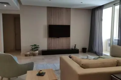 a living room with a couch and a flat screen tv at Mangroovy Magic PoolView 1BR in Beachfront Complex M3 3A 13 in Hurghada