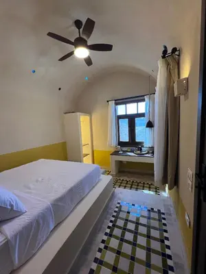 a bedroom with a bed and a ceiling fan at Ayujidda Nubian House in Aswan
