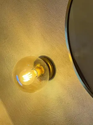 a yellow light on a wall next to a mirror at Ayujidda Nubian House in Aswan