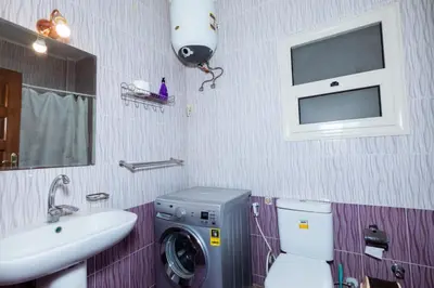 a bathroom with a washing machine and a sink at Makramia A107 studio in Hurghada