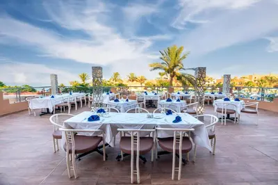 a restaurant with white tables and chairs on a roof at Akassia Swiss Resort in Quseir