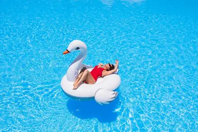 a woman is riding on anlatable swan in a pool at Akassia Swiss Resort in Quseir