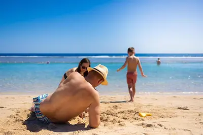 a man laying in the sand on a beach at Akassia Swiss Resort in Quseir