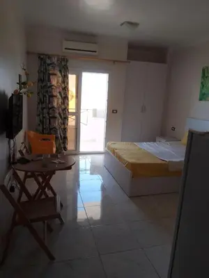 a bedroom with a bed and a table and a chair at Tiba View flat near pool in Hurghada