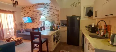 a kitchen with a refrigerator and a table with chairs at 1 Bed Apartment with Public Pool HotTub & PetsOk in Hurghada