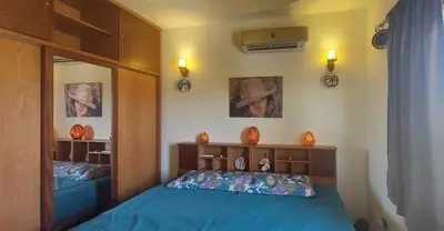 a bedroom with a blue bed and a mirror at 1 Bed Apartment with Public Pool HotTub & PetsOk in Hurghada