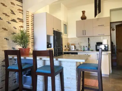 a kitchen with two bar stools and a counter at 1 Bed Apartment with Public Pool HotTub & PetsOk in Hurghada