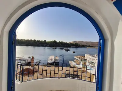 an arched window with a view of a marina at NOBATiA Guest House 2 in Aswan