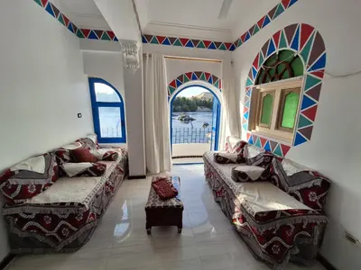 a living room with two beds and a window at NOBATiA Guest House 2 in Aswan