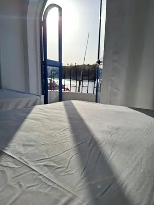 a white bed in a room with a window at NOBATiA Guest House 2 in Aswan