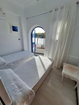 a bedroom with two beds and a window at NOBATiA Guest House 2 in Aswan