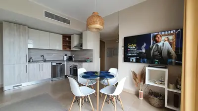 a kitchen with a table and chairs and a tv at El Gouna Mangroovy Residence Sea View - kitesurfing in Hurghada