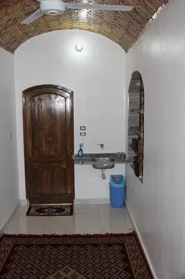 a bathroom with a sink and a wooden door at Ajwa Guest House in Aswan