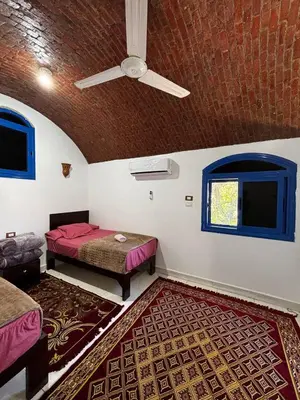 a room with two beds and a ceiling fan at Ajwa Guest House in Aswan