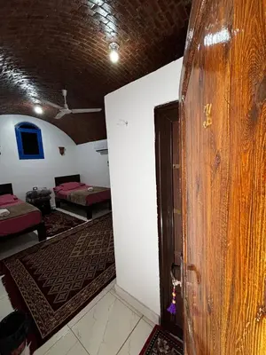 a room with a door and a room with two beds at Ajwa Guest House in Aswan