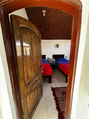 an open door in a room with two beds at Ajwa Guest House in Aswan