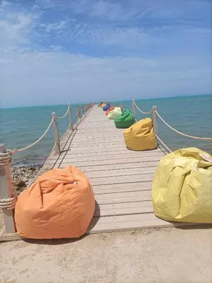 a row of bean bags lined up on a wooden pier at Royal Beach Hurghada in Hurghada