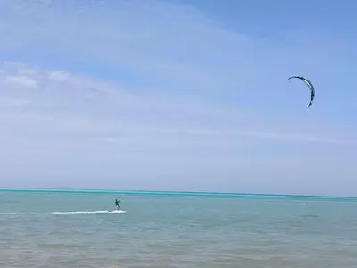 a person is flying a kite in the ocean at Royal Beach Hurghada in Hurghada