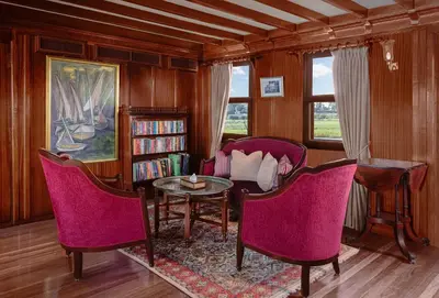 a living room with pink chairs and a table at Farouz El Nil I Nile Cruise - Every Monday from Luxor for 07 & 05 Nights in Ţawd