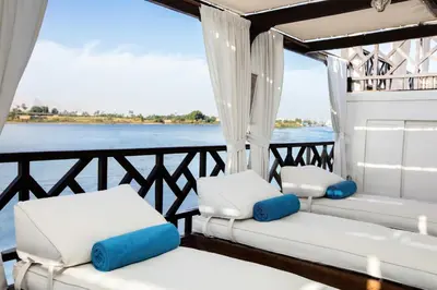 a boat with three chairs and a view of the water at Farouz El Nil I Nile Cruise - Every Monday from Luxor for 07 & 05 Nights in Ţawd