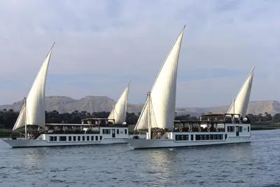 two boats with white sails in the water at Farouz El Nil I Nile Cruise - Every Monday from Luxor for 07 & 05 Nights in Ţawd