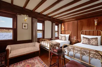 a bedroom with two beds and a chair and a couch at Farouz El Nil II Nile Cruise - Every Monday from Luxor for 07 & 05 Nights in Luxor