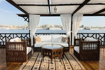 a porch with a couch and chairs and a table at Farouz El Nil II Nile Cruise - Every Monday from Luxor for 07 & 05 Nights in Luxor