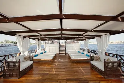 a boat with white seats on a body of water at Farouz El Nil II Nile Cruise - Every Monday from Luxor for 07 & 05 Nights in Luxor