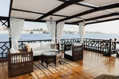 a living room with a couch and chairs on a boat at JAZ Farouz El Nil III Nile Cruise - Every Saturday from Luxor for 07 & 05 Nights in Luxor