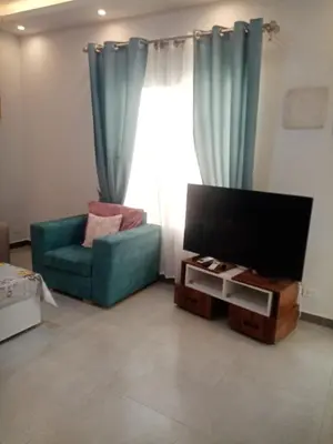 a living room with a green couch and a television at A216 flat Al Makramia in Hurghada
