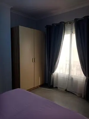 a bedroom with a bed and a large window at A216 flat Al Makramia in Hurghada