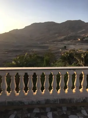 a white balcony with a view of a mountain at Tibs mountain view in Al Aqālitah