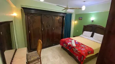 a bedroom with a bed with a wooden headboard at Tibs mountain view in Al Aqālitah